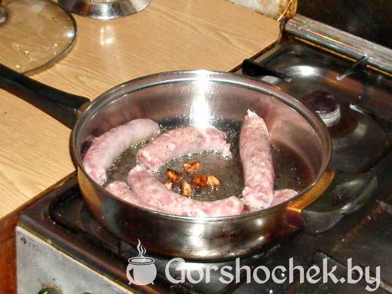 Капуста тушеная с мясными колбасками выкладываем колбаски в сковородку
